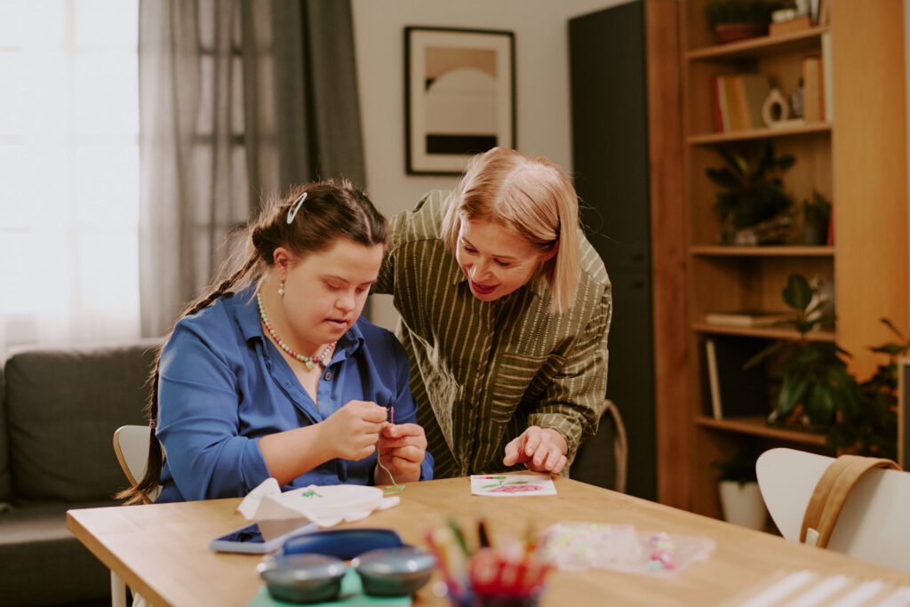 Young adult practicing life skills activity with support staff