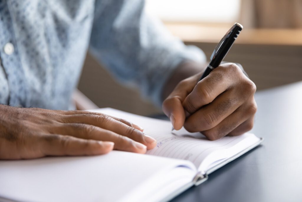 Person writing in a journal for mental health self-reflection and personal growth