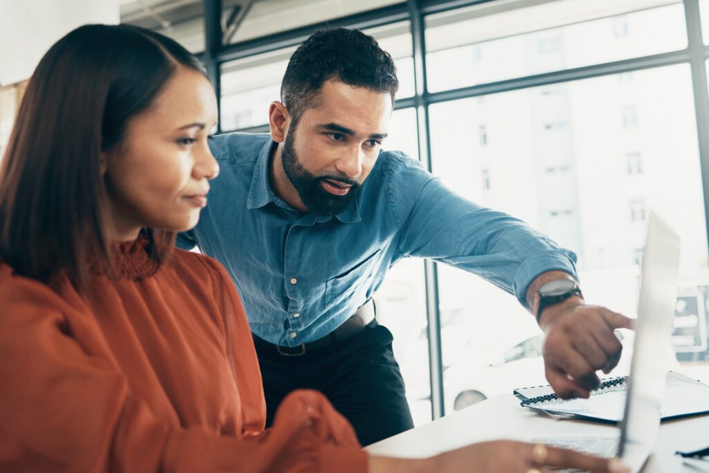 Two people collaborating and navigating mental health resources on a computer